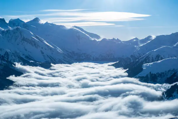 Skiiing at Zillertal - mountain snow Panorama with clouds and fog with blue sunny sky