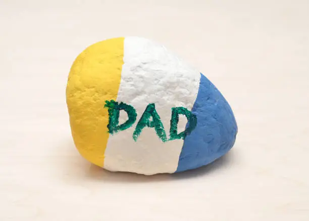 Closeup of a homemade painted rock turned paperweight for a Father's Day gift.