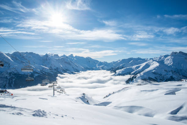 Skiiing at Zillertal - mountain snow Panorama with clouds and fog with blue sunny sky