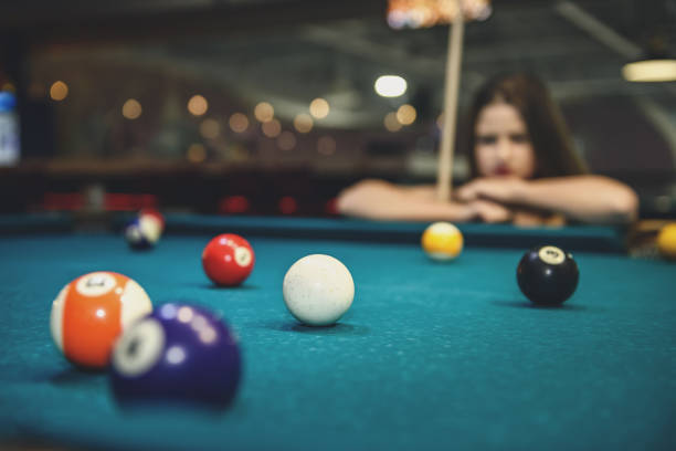 istock Beautiful woman looking at billiard balls on table 1131458547