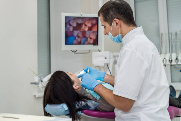 dentista que verific os dentes do paciente com a câmera no estomatologia - medical exam dental hygiene caucasian mask - fotografias e filmes do acervo