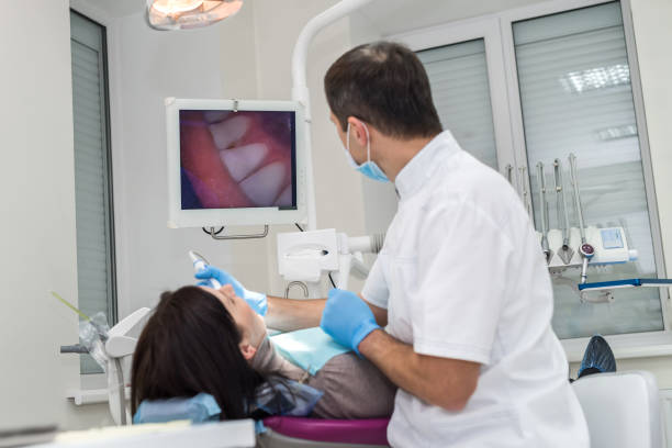 dentista que verific os dentes do paciente com a câmera no estomatologia - medical exam dental hygiene caucasian mask - fotografias e filmes do acervo