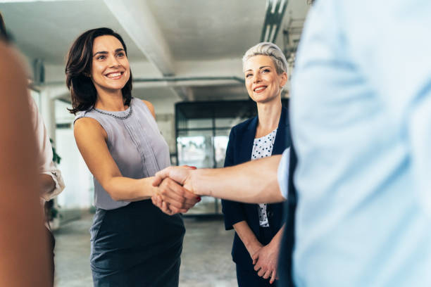 geschäftsdeal mit handschlag - adult businesswoman greeting human hand stock-fotos und bilder