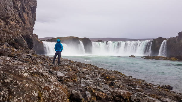 istock Iceland - Man standing in front of Godafoss 1131462564