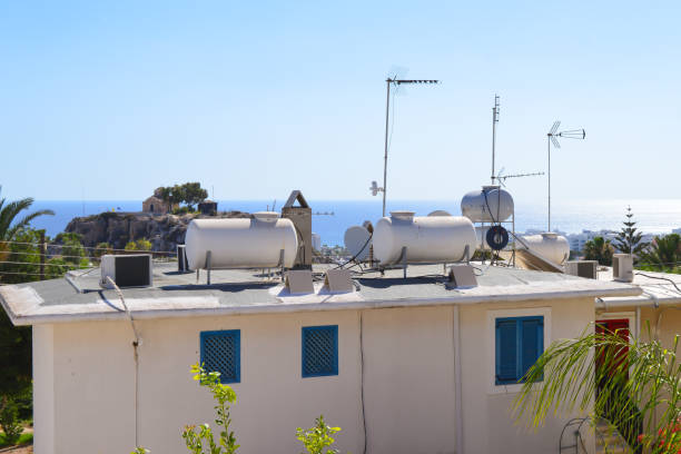 Water tanks warmed by sun on cottage rooftop, Cyprus