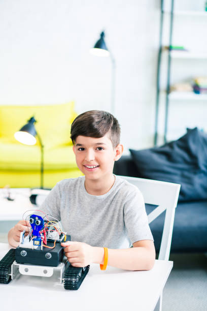 istock Waist up of a joyful smiling boy using robotic technologies 1131464870