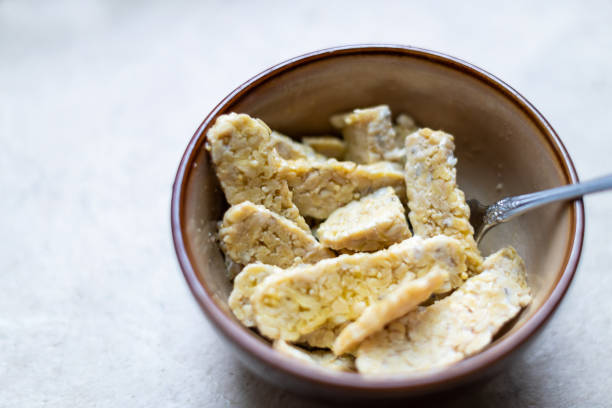 primer plano de tazón de fuente de soja fermentada tempeh cortada en el ingrediente de cocina de la tabla - tempeh fotografías e imágenes de stock