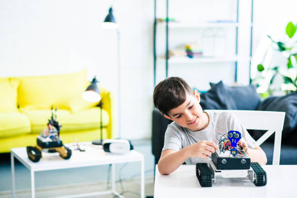 istock Ingenious smart boy adjusting his robotic device at home 1131465856