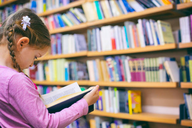 istock Girl reading a book at the library 1131471490