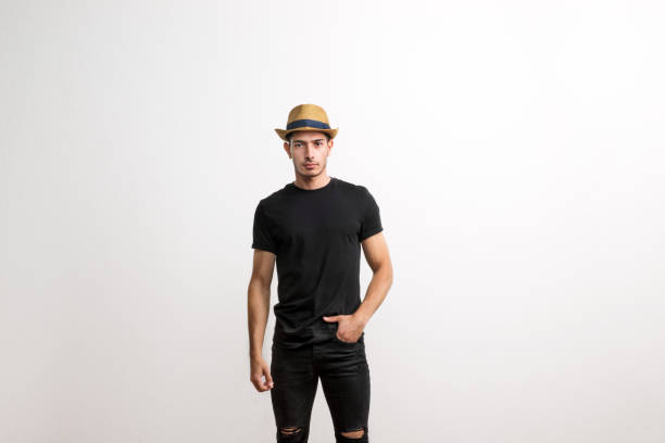 istock A confident hispanic young man with hat and black T-shirt in a studio. 1131471513
