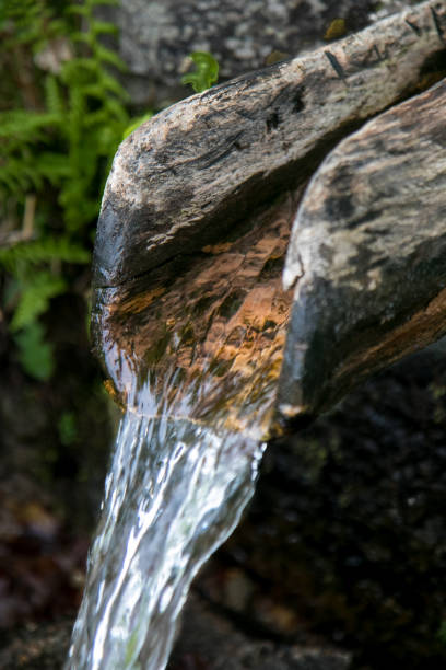 istock Water coming from a traditional wooden pipe 1131471742