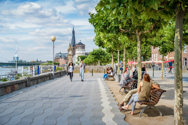People relax on the Rhine River promenade in downtown Dusseldorf,  North Rhine-Westphalia, Germany on a sunny day.