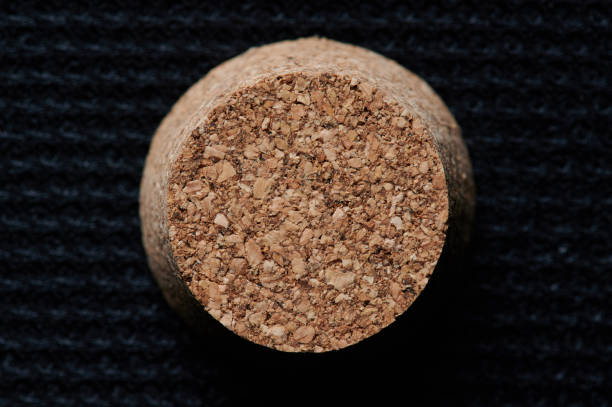 Round brown wooden cork above top view on black background