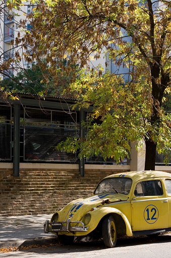 Buenos Aires, Argentina - April 13, 2013: Old and deteriorated WV Beetle painted as a sports car parked in the street next to sidewalk. There are lots of abandoned cars in the city that the government has to take care of
