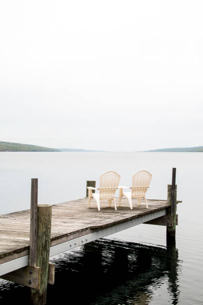 adirondack-stühle auf einem dock am seneca lake new york - adirondack chair stock-fotos und bilder