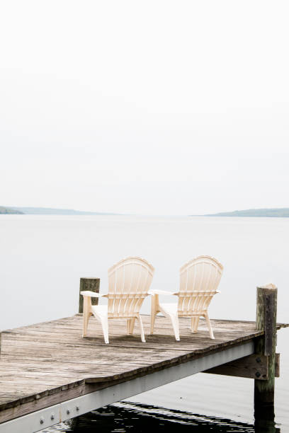 adirondack-stühle auf einem dock am seneca lake new york - adirondack chair stock-fotos und bilder