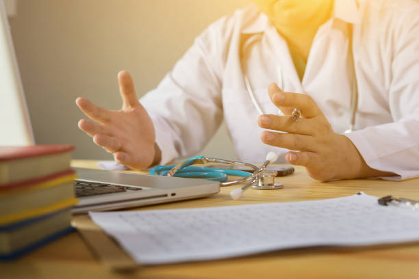 istock Doctor and patient are discussing something, just hands at the table,explaining prescription to victim,stethoscope and laptop computer on desk in hospital healthcare and medical insurance concept 1131508309