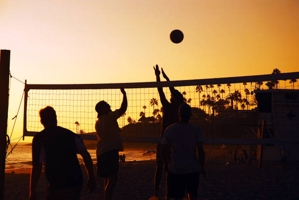 Laguna Beach, CA, USA September 23, 2008 Young adults play a friendly game of beach volleyball in Laguna Beach, California at sunset