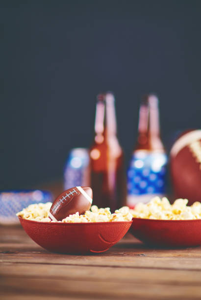 time to watch football on tv. popcorn with american football - american football football food snack imagens e fotografias de stock