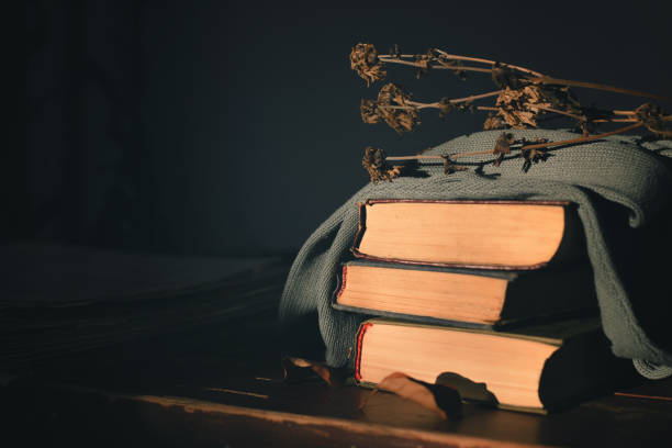 istock three old books covered with a cloth with lie on the table  a dry withered flower on top 1131514351