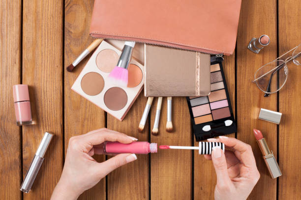 Makeup products with woman opens her lipstick