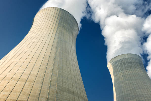 istock power plant cooling towers steaming on dark blue sky background 1131533445