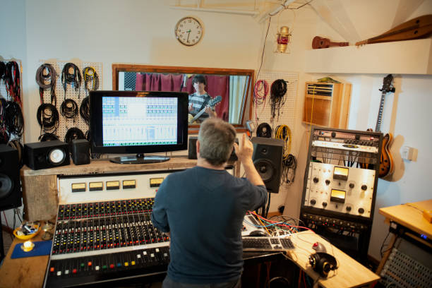 ingegnere del suono che segnala musicista nella sala di registrazione dello studio - sound effect foto e immagini stock