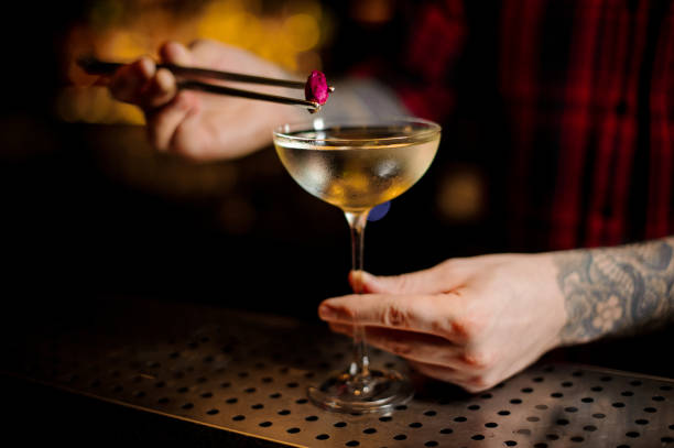 istock Barman hand decorating elegant cocktail with a little rose bud 1131536644