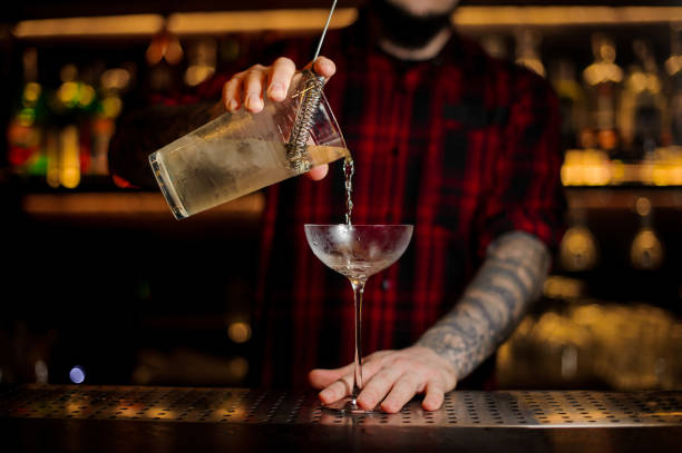 istock Bartender pouring alcoholic cocktail into a glass 1131536768