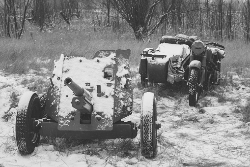 Russian Soviet 45mm Anti-tank Gun And Old Tricar, Three-Wheeled Motorbike. Main Anti-tank Weapon Of Red Army Artillery Units In World War WW II. Winter Season. Photo In Black And White Colors.