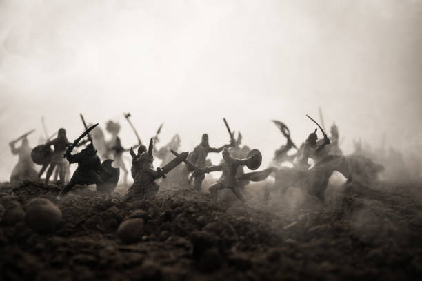istock Medieval battle scene with cavalry and infantry. Silhouettes of figures as separate objects, fight between warriors on sunset foggy background. Selective focus 1131540130