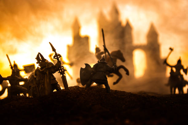 istock Medieval battle scene with cavalry and infantry. Silhouettes of figures as separate objects, fight between warriors on sunset foggy background. 1131540155