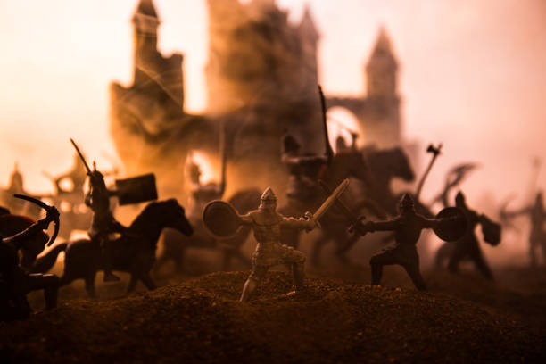 istock Medieval battle scene with cavalry and infantry. Silhouettes of figures as separate objects, fight between warriors on sunset foggy background. 1131540157