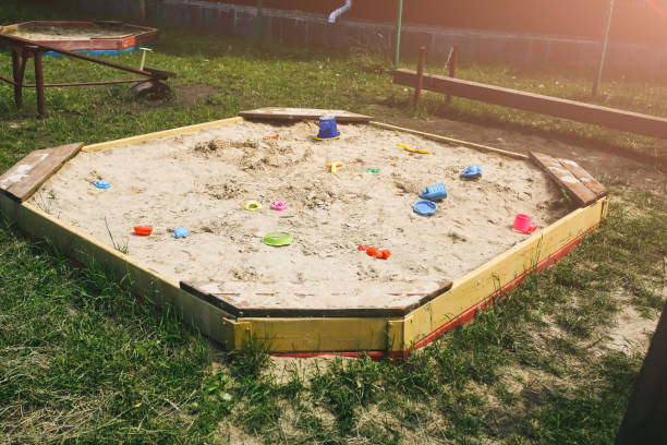 Sandbox on the children playground with colourful toys. Free time outdoors for kids. Sandpit for the entertainment. Sandbox on the children playground with colourful toys. Free time outdoors for kids. Sandpit for the entertainment. sandbox photos stock pictures, royalty-free photos & images