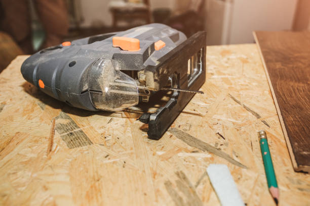 istock Working instruments lying on OSB background. Power jigsaw, scroll saw and pencil on the table. Maintenance repair works renovation in the flat. 1131540466