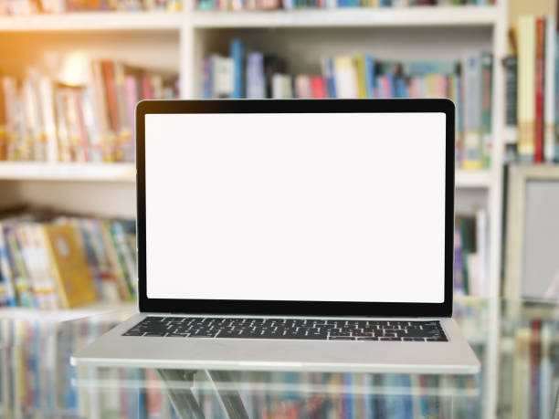 istock Blank laptop on glass table with bookshelf background. 1131542609