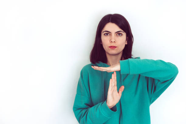 Woman making time out hand gesture with a white background copy-space An image of a woman who is making time out hand gesture with a white background. time out signal stock pictures, royalty-free photos & images