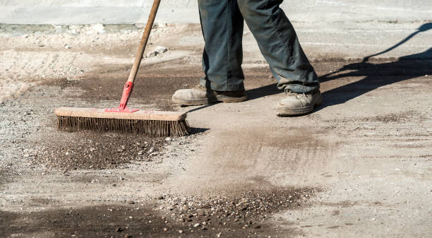 istock Worker with brush collects and dumps dirt and debris. 1131548264