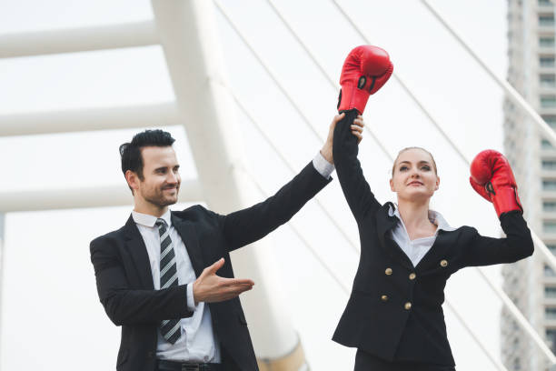 femme d'affaires avec des gants de boxe rouges - women business strength boxing photos et images de collection