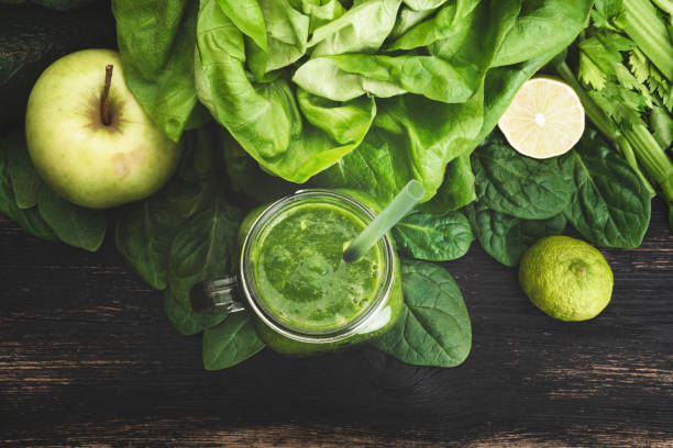 Green vegetable juice on wooden background