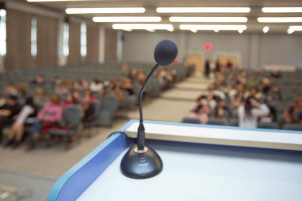 before a conference, the microphones in front of empty chairs. Close up of microphone in conference room . Microphone in Conference Seminar room Event Background