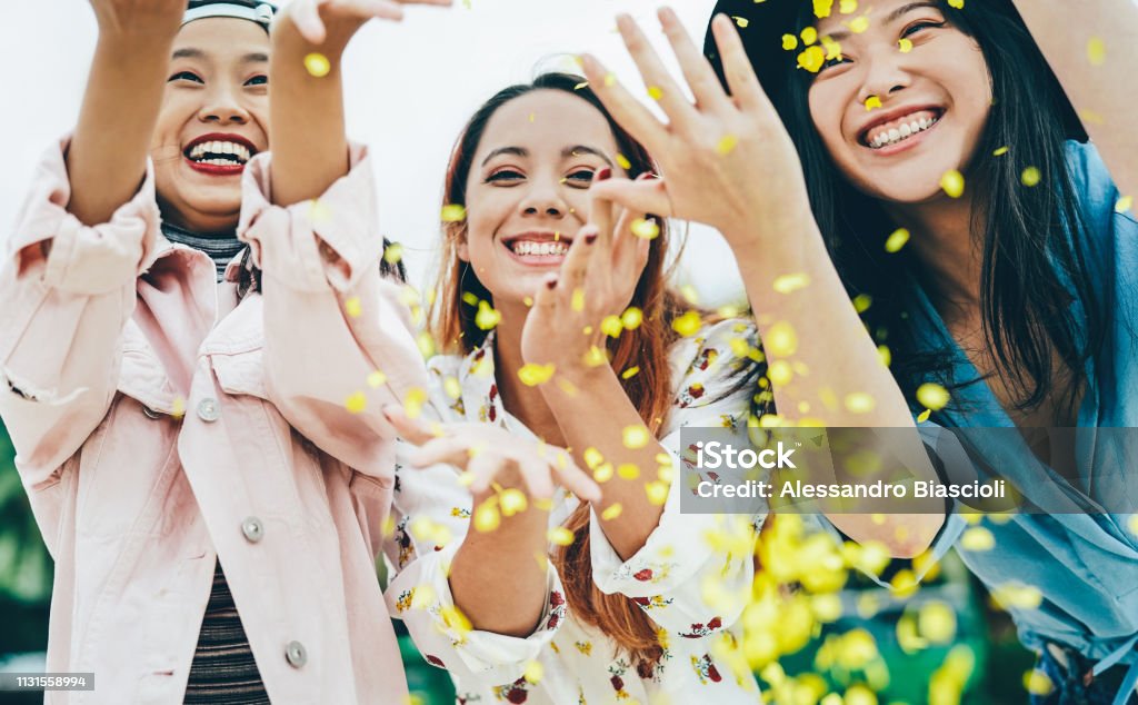 Amis asiatiques heureux ayant amusant jetant des confettis en plein air-jeunes gens tendance célébrant à l'événement de Festival à l'extérieur-concept de mode de vie de fête, de divertissement et de vacances de jeunesse - Photo de Asie libre de droits