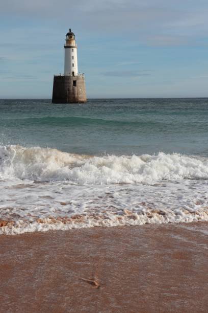 istock White lighthouse on granite platform in sea with copy space 1131559423