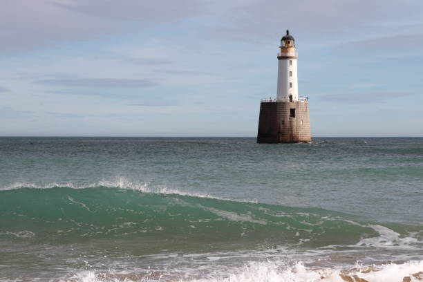 istock White lighthouse on granite platform in sea with copy space 1131559464