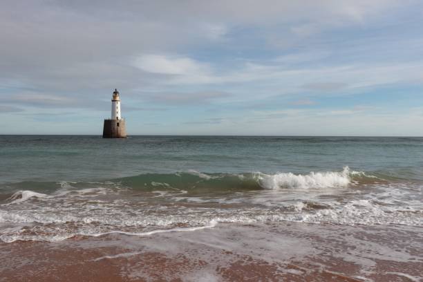 istock White lighthouse on granite platform in sea with copy space 1131559505