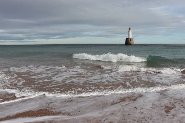 istock White lighthouse on granite platform in sea with copy space 1131559547