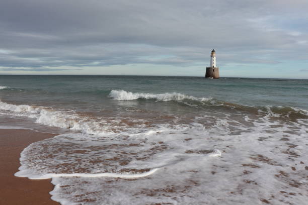 istock White lighthouse on granite platform in sea with copy space 1131559555