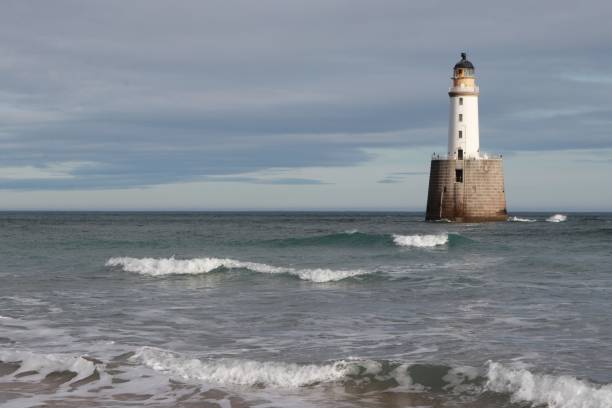 istock White lighthouse on granite platform in sea with copy space 1131559631