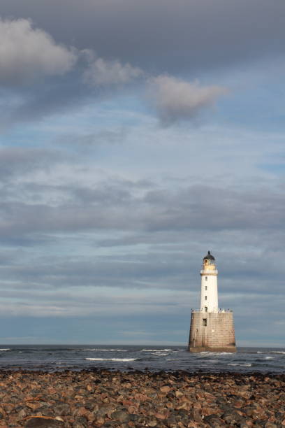 istock White lighthouse on granite platform in sea with copy space 1131559732
