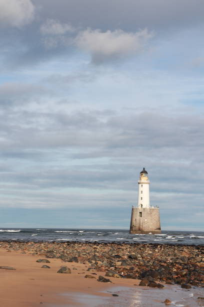 istock White lighthouse on granite platform in sea with copy space 1131559735